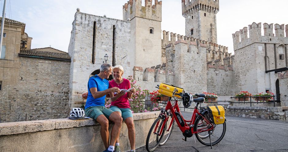 Cyclists in front of the castle in Sirmione on Lake Garda