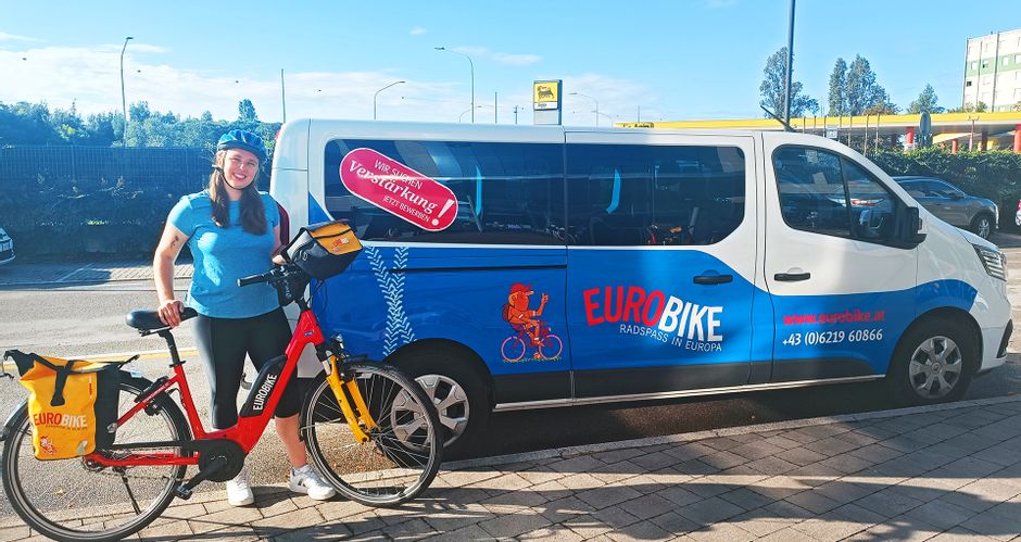 Cyclist with e-bike in front of Eurobike bus