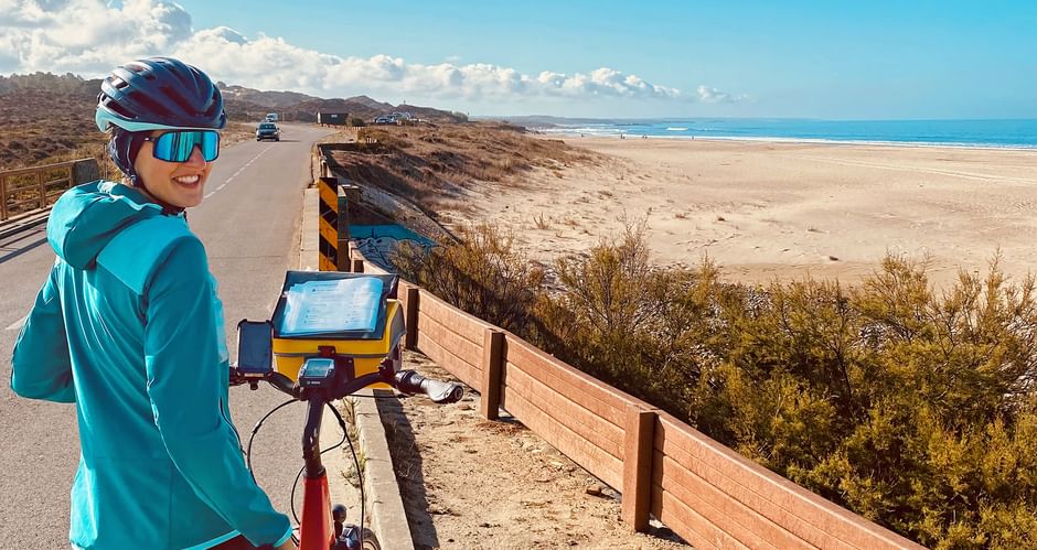 Cyclist on the road with beach and sea in the background