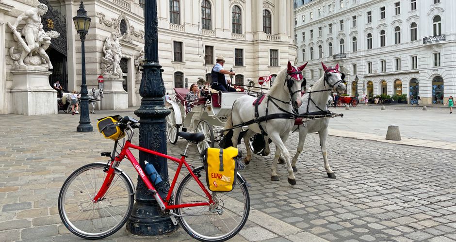 Radpause vor der Hofburg in Wien, mit einem Fiaker im Hintergrund