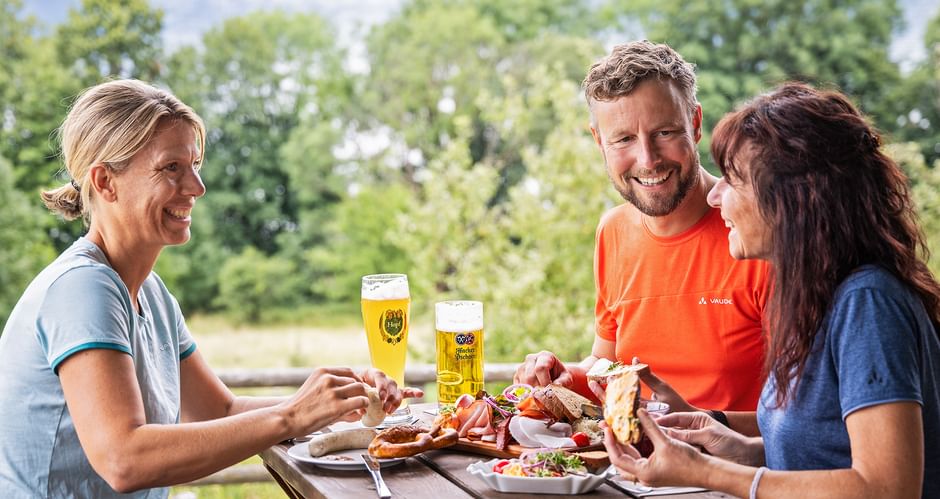 Drei Personen machen Brotzeit am Tegernsee in Kaltenbrunn